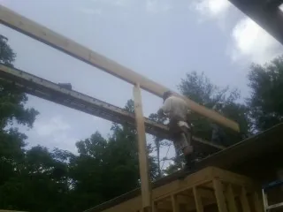 Carpenter setting a ridge beam over a new addition frame — Ice Dam Removal by Roofing Brothers in Balaton