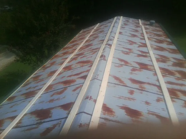 Rusted metal roof panels with new wood purlins before replacement — Storm Damage Roof Repair in Balaton by Roofing Brothers