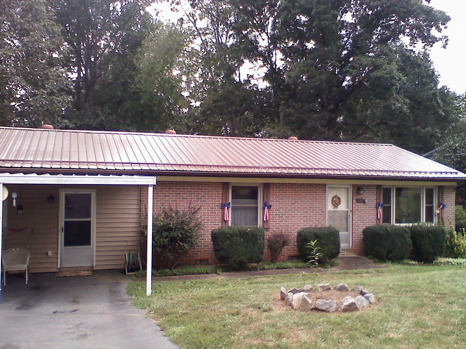 Bronze metal roof and carport on a brick ranch home — Roof Repair work by our crew in Balaton